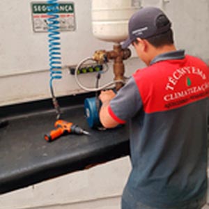 Técnico Hidrotek com uniforme da empresa realizando conserto de pressurizador Rowa com ferramentas profissionais